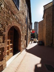 an alley with an archway in a brick building at Antica Posta in San Gimignano