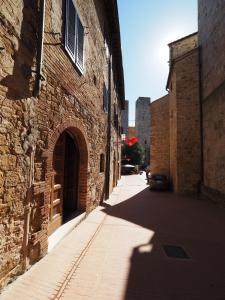 an alley with a brick building and a car on a street at Antica Posta in San Gimignano +28 photos