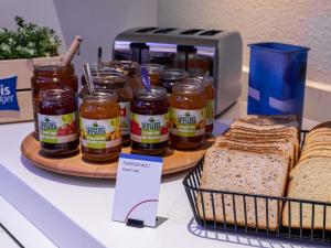 a counter with bread and jars of jam and peanut butter at Ibis budget Brest Sud Plougastel - Hôtel rénové in Plougastel-Daoulas