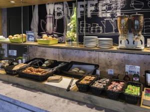 a buffet with bread and other food on display at Ibis Budget Bollene in Bollène