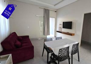 a living room with a couch and a table and chairs at Casa Indaiá in Primavera do Leste