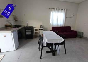 a kitchen and a living room with a table and chairs at Casa Indaiá in Primavera do Leste