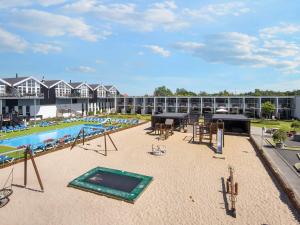 a swimming pool with tables and chairs and a building at 6 person holiday home in Glesborg in Glesborg