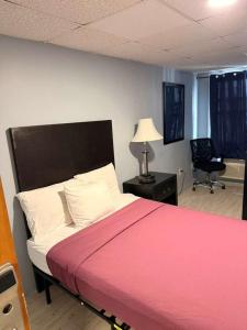 a bedroom with a bed and a desk with a chair at Hammock Inn & Suites North Beach Hotel in Seaside Heights