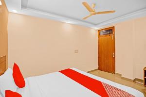 a bedroom with a bed and a ceiling fan at Hotel O Happy Spring in New Delhi +18 photos