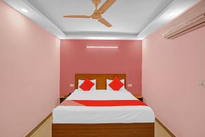 a bedroom with a bed with a ceiling fan at Hotel O Happy Spring in New Delhi