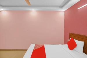 a bedroom with a bed with a red pillow at Hotel O Happy Spring in New Delhi