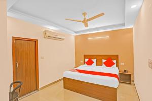 a bedroom with a bed with red pillows at Hotel O Happy Spring in New Delhi