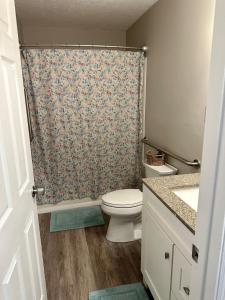 a bathroom with a toilet and a shower curtain at Twin Oaks Haven in Murfreesboro +17 photos