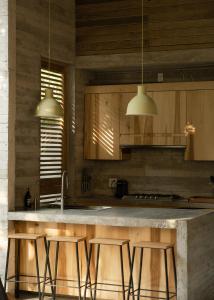 a kitchen with wooden cabinets and a counter with stools at Casa Macu Boutique Homes in La Salada +75 photos
