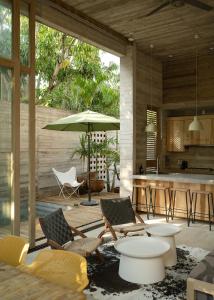 a patio with chairs and a table with an umbrella at Casa Macu Boutique Homes in La Salada