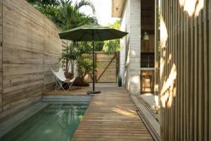 an umbrella is sitting next to a swimming pool at Casa Macu Boutique Homes in La Salada