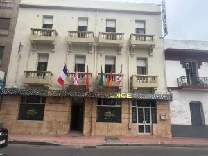 a building with flags on the front of it at Hotel De Provence in El Jadida
