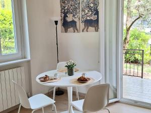 a white table and chairs in a room with a window at Il Giardinetto in Riva di Solto +8 photos
