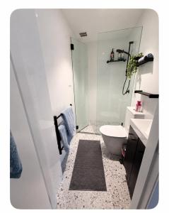 a bathroom with a white toilet and a sink at Modern Studio in Sydney