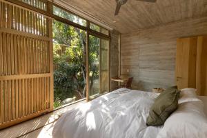 a bedroom with a bed and a large window at Casa Macu Boutique Homes in La Salada