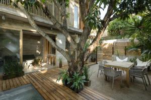 a wooden deck with a table and a tree at Casa Macu Boutique Homes in La Salada