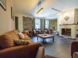 a living room with a couch and a fireplace at Moderscheid Cottage with Spa in Amblève +28 photos