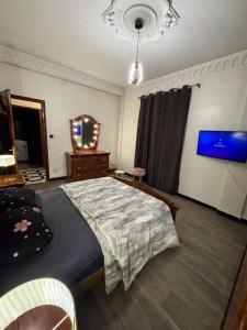 a bedroom with a large bed and a mirror at Maison moderne & cosy in Constantine
