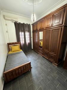 a bedroom with a bed and wooden cabinets at Maison moderne & cosy in Constantine +10 photos