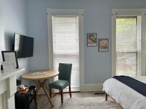 a bedroom with a table and a chair and a bed at 50 Lincoln Short North Bed & Breakfast in Columbus