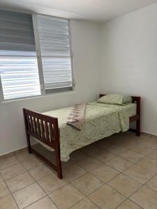 a bedroom with a bed and a chair and a window at josedith'sweet house in Isabela