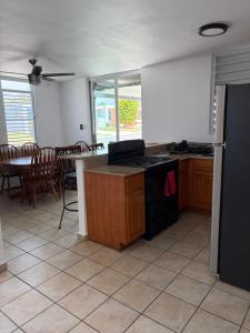 a kitchen with a stove and a table with chairs at josedith'sweet house in Isabela +9 photos