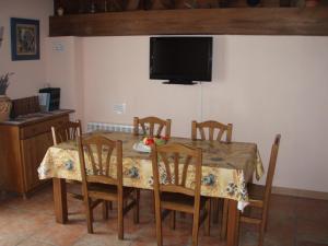 mesa de comedor con sillas y TV en la pared en Casa Rural Irugoienea en Espinal-Auzperri