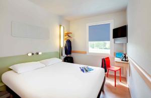 a bedroom with a white bed and a window at ibis budget Saint Pourcain in Saint-Pourçain-sur-Sioule +74 photos