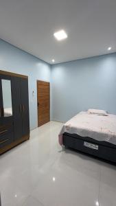 a bedroom with a bed and a dresser at Casa moderna próximo ao bumbodromo in Parintins