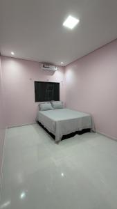 a bedroom with a bed in a white room at Casa moderna próximo ao bumbodromo in Parintins
