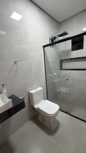 a bathroom with a toilet and a shower and a sink at Casa moderna próximo ao bumbodromo in Parintins