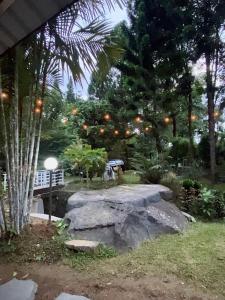 a stone bench in a garden with trees and lights at Villa Arkhazio in Megamendung