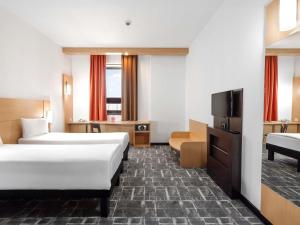 a hotel room with two beds and a flat screen tv at Ibis Astana in Astana +229 photos