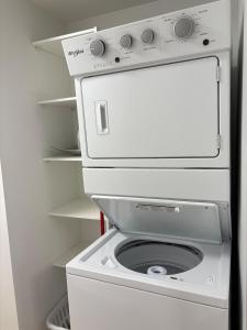 a white washer and dryer in a refrigerator at Upscale One Bedroom Suite in New Build in Kelowna