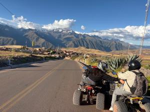 two people riding on motorcycles down a road at Refugio del Valle del Sol in Urubamba +10 photos