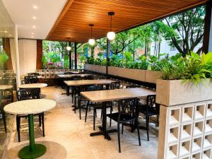 a restaurant with tables and chairs and plants at Hotel Laureles Loft in Medellín