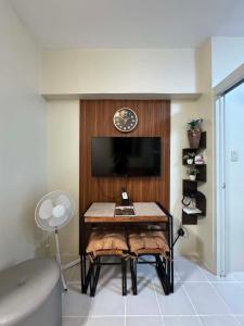 a room with a table and a clock on a wall at Maldee's Place Tagaytay Prime Residences in Tagaytay