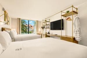 a bedroom with a white bed and a tv at The Bower Coronado in San Diego