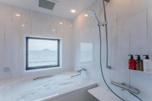 a bathroom with a shower and a sink and a window at THE SHIKAKA Hotel&Resort BUDOUNOKI in Itoshima +51 photos