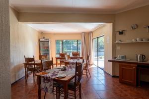 a kitchen and dining room with tables and chairs at The Bedford View Guest House in Germiston