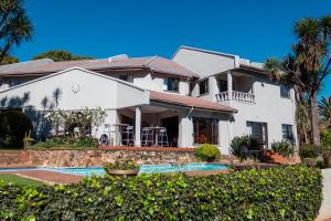 a large white house with a swimming pool at The Bedford View Guest House in Germiston