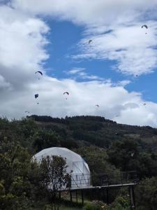 a bunch of kites flying in the sky at Glamping hermoso amanecer in Guatavita