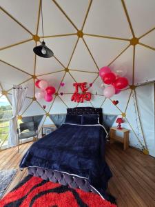 a room with a bed in a tent with balloons at Glamping hermoso amanecer in Guatavita