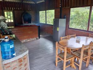 a kitchen with a table and chairs and a stove at Rancho San Andrés in Palora +2 photos