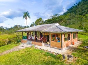 a small house in a field with a palm tree at Rancho San Andrés in Palora