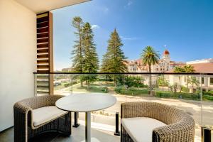 a balcony with a table and chairs and a large window at The Bower Coronado in San Diego