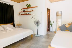 a bedroom with two beds and a fan at Kabilin Homestay in General Luna