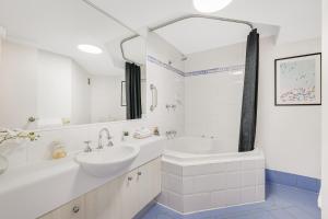 a white bathroom with a sink and a tub and a sink at Nautilus Resort - Private Apartment in Mooloolaba +14 photos
