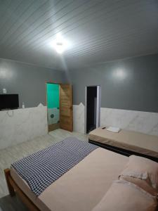 a bedroom with a bed and a television in it at Hospedagem e queijaria Péua in Soure